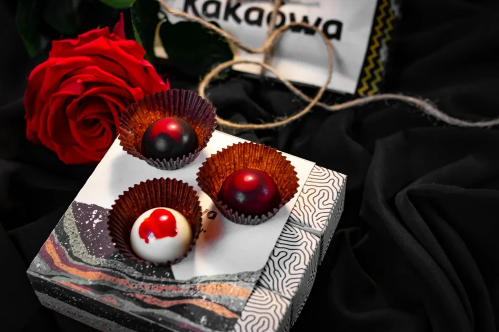 Bombones Kakaówa con una rosa roja sobre tela negra